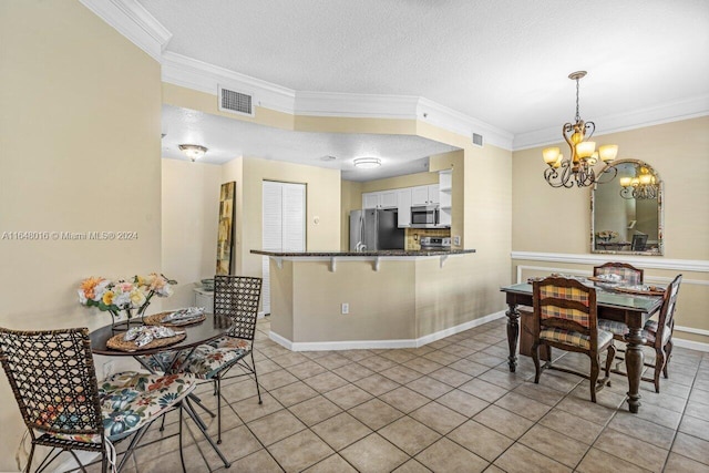 tiled dining room featuring a chandelier, a textured ceiling, and ornamental molding