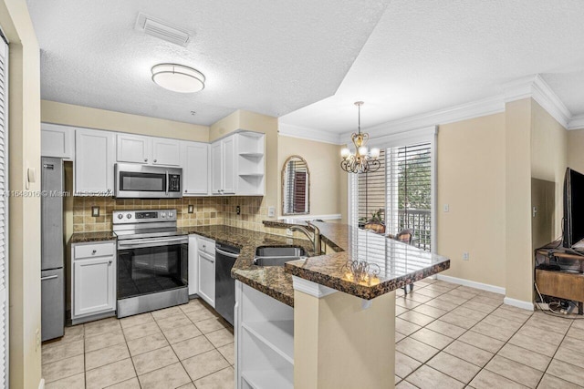 kitchen featuring light tile patterned floors, kitchen peninsula, stainless steel appliances, and hanging light fixtures