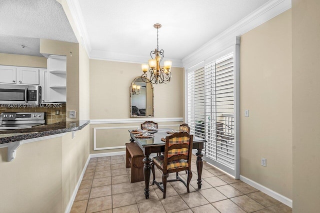 tiled dining area with ornamental molding, a textured ceiling, and an inviting chandelier