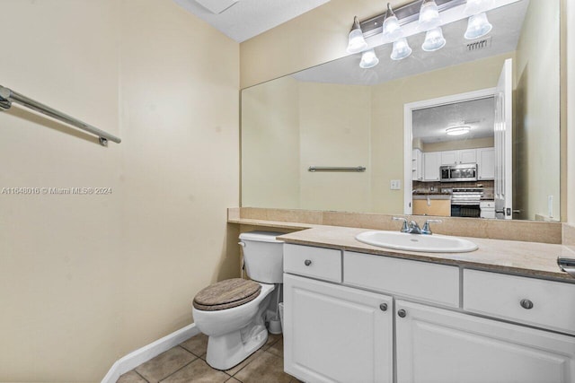 bathroom featuring vanity, toilet, a textured ceiling, and tile patterned flooring