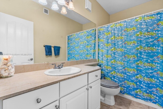 bathroom with vanity, toilet, a textured ceiling, and tile patterned flooring