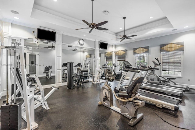 workout area featuring a tray ceiling, ornamental molding, and ceiling fan