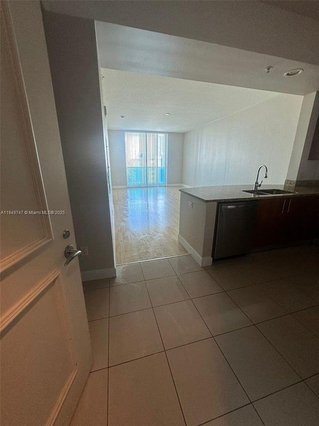 kitchen featuring dishwasher, sink, and light tile patterned floors