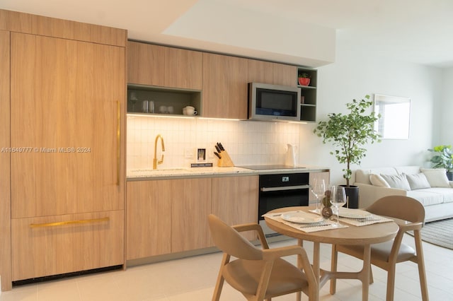 kitchen with modern cabinets, black appliances, open shelves, a sink, and backsplash