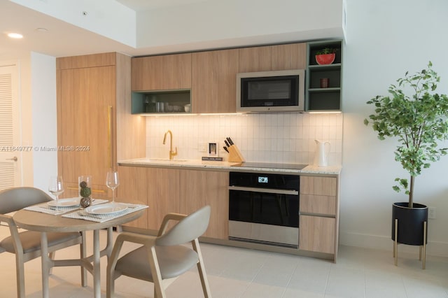 kitchen featuring tasteful backsplash, stainless steel oven, light stone counters, black electric cooktop, and open shelves