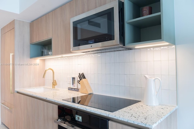 kitchen with stainless steel microwave, open shelves, oven, modern cabinets, and a sink