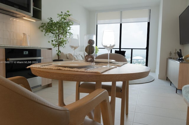 dining room with a wealth of natural light, expansive windows, and light tile patterned flooring