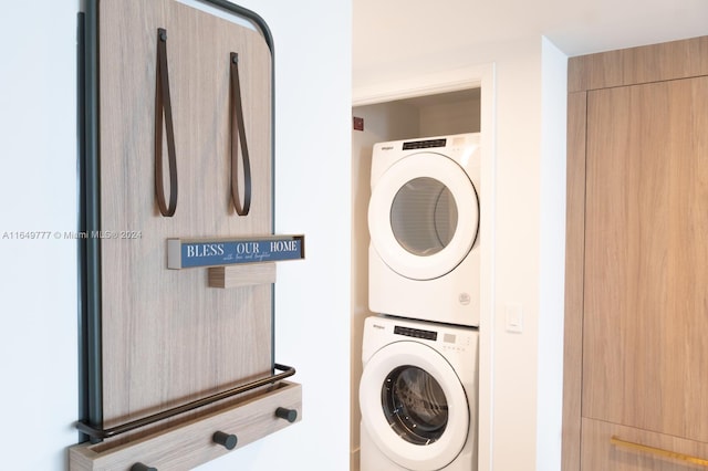 clothes washing area with laundry area and stacked washer and dryer