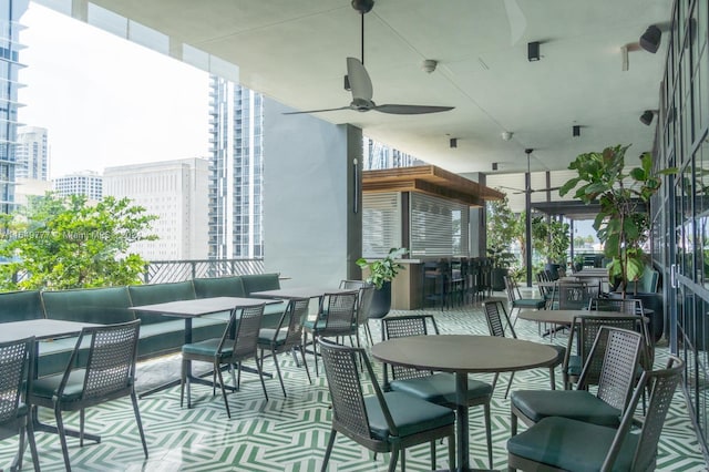 view of patio featuring a city view, an outdoor hangout area, outdoor dining area, and ceiling fan