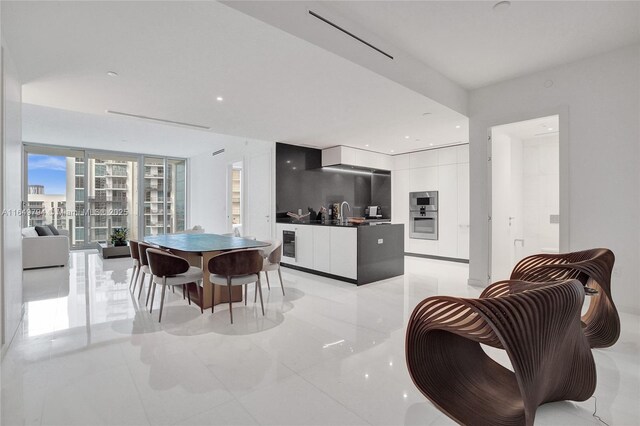 kitchen with range hood, decorative backsplash, sink, white cabinets, and black electric cooktop