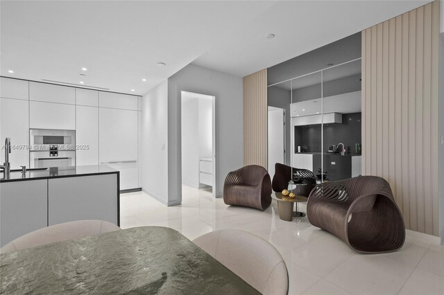 kitchen featuring white cabinets, sink, backsplash, light tile patterned floors, and black electric cooktop