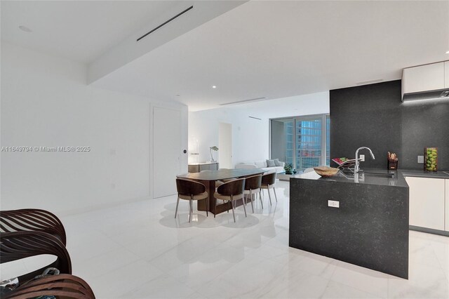 kitchen featuring beverage cooler, white cabinets, tasteful backsplash, and stainless steel double oven