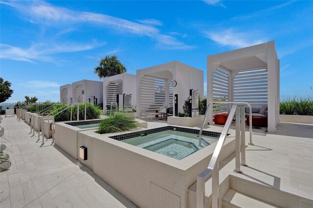 view of swimming pool featuring a water view and a jacuzzi