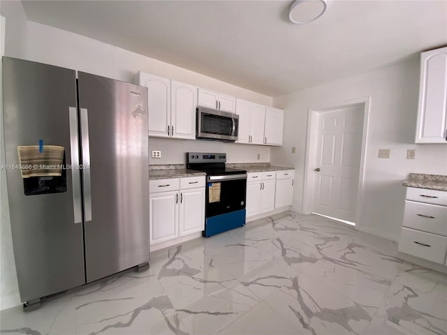 kitchen featuring appliances with stainless steel finishes, white cabinetry, and light tile patterned flooring