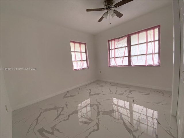 tiled spare room with ceiling fan