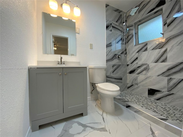 bathroom featuring tiled shower, vanity, toilet, and tile patterned floors