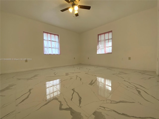 empty room featuring ceiling fan and light tile patterned floors