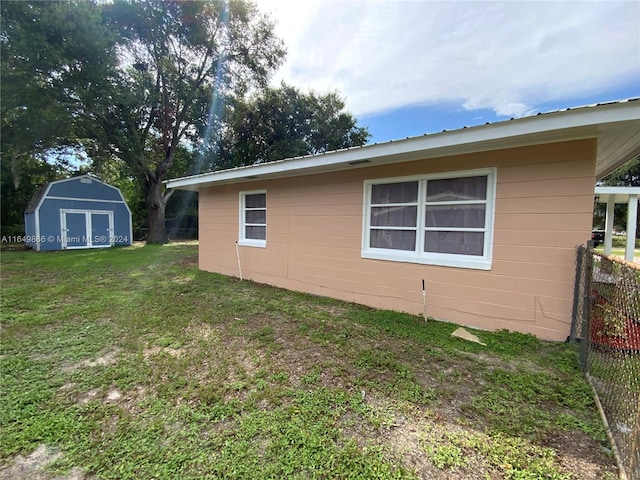 view of home's exterior with a yard and a storage shed