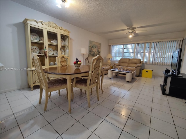 tiled dining room featuring ceiling fan and a textured ceiling