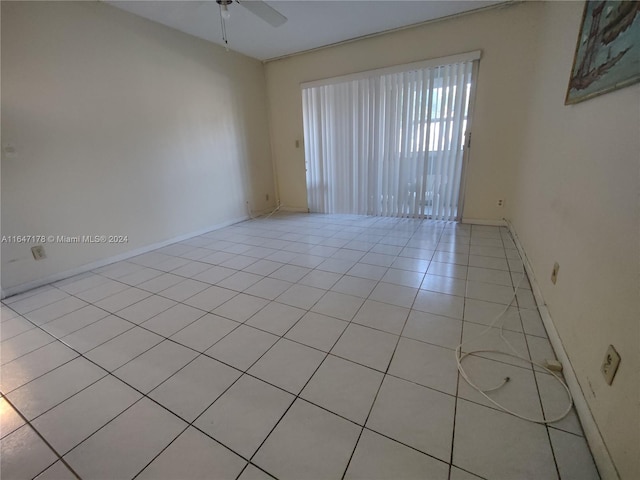 tiled spare room with ceiling fan