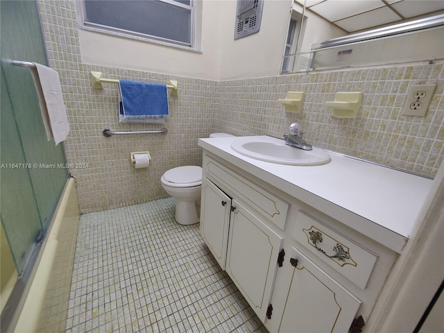 full bathroom featuring tile walls, tile patterned flooring, enclosed tub / shower combo, vanity, and toilet