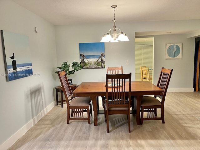 dining room featuring light wood-type flooring and a notable chandelier