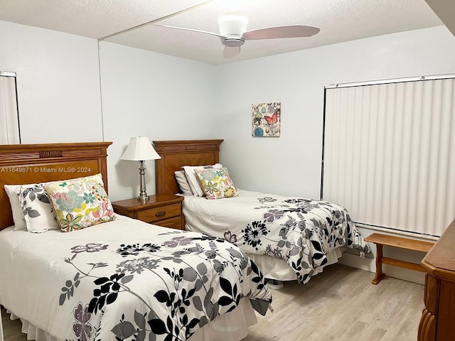 bedroom featuring a textured ceiling, ceiling fan, and light wood-type flooring