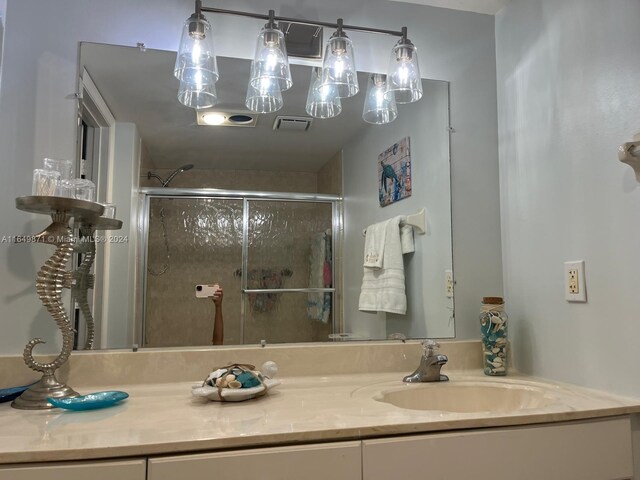 bathroom with a shower with door and vanity