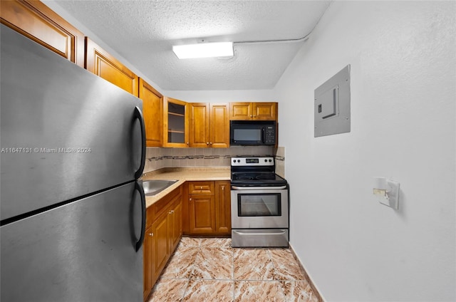 kitchen with electric panel, sink, backsplash, appliances with stainless steel finishes, and a textured ceiling