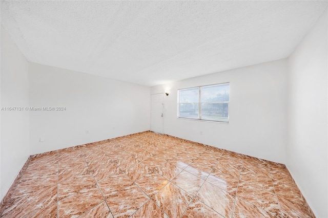 unfurnished room featuring a textured ceiling