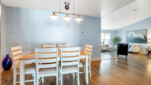 dining area featuring lofted ceiling and light hardwood / wood-style floors