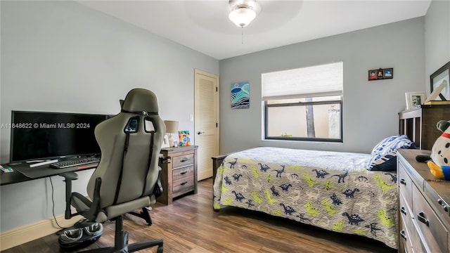 bedroom featuring dark wood-type flooring, a closet, and ceiling fan