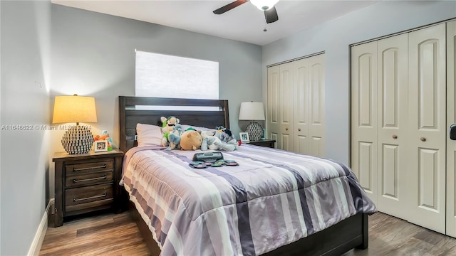 bedroom with ceiling fan, wood-type flooring, and multiple closets