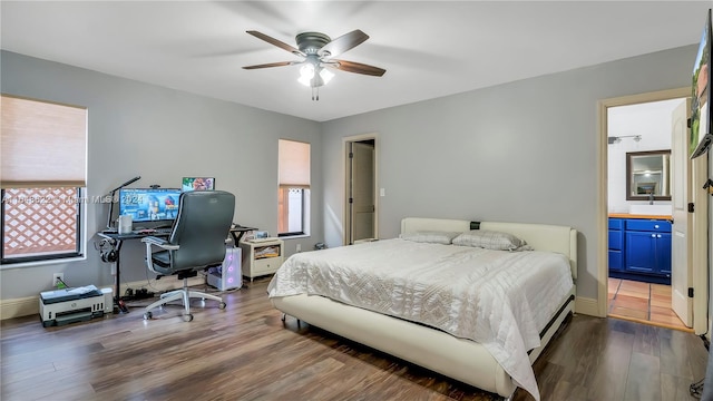 bedroom featuring ceiling fan, dark hardwood / wood-style floors, and ensuite bath