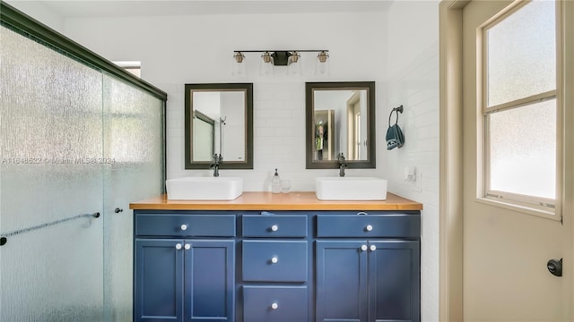 bathroom featuring walk in shower and vanity