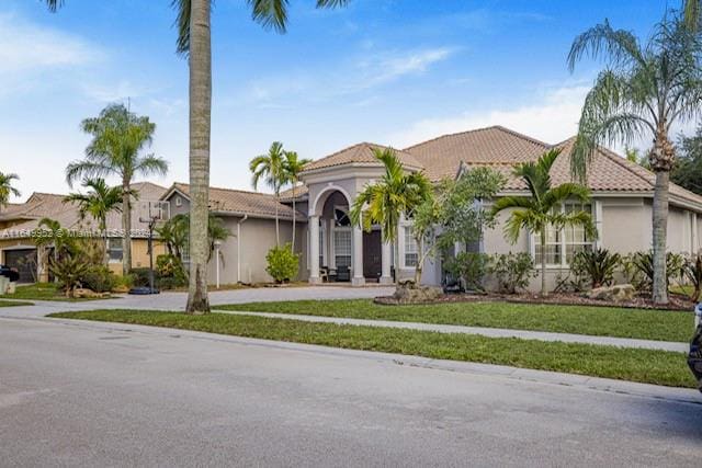 mediterranean / spanish home with a front lawn