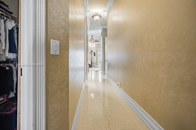 hallway with crown molding and light tile patterned floors