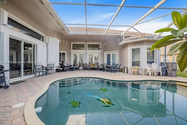 view of swimming pool with a patio area, glass enclosure, and french doors