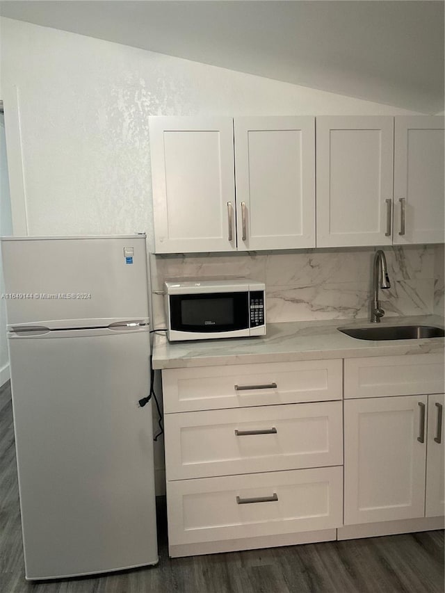 kitchen featuring white fridge, dark hardwood / wood-style floors, sink, decorative backsplash, and lofted ceiling