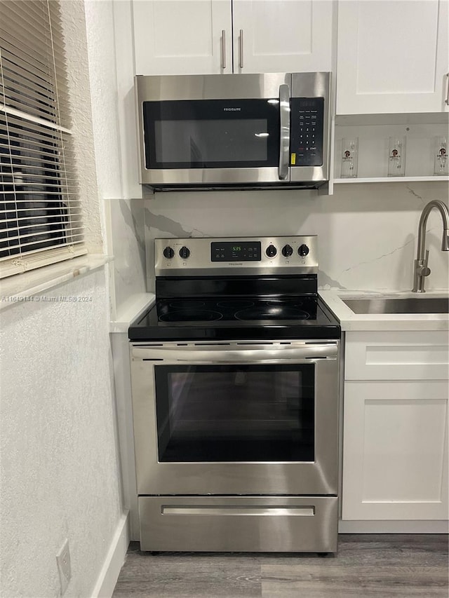 kitchen featuring white cabinetry, hardwood / wood-style floors, stainless steel appliances, and sink