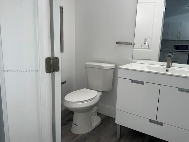 bathroom featuring toilet, hardwood / wood-style flooring, and vanity