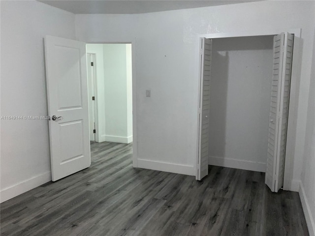 unfurnished bedroom featuring a closet and dark hardwood / wood-style floors