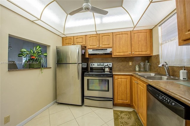 kitchen with backsplash, light tile patterned floors, appliances with stainless steel finishes, sink, and ceiling fan