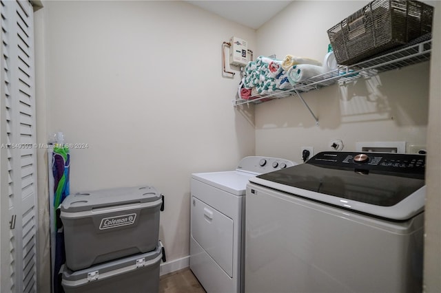 clothes washing area featuring washing machine and dryer and dark hardwood / wood-style flooring