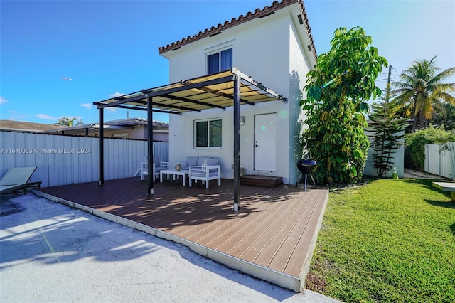 rear view of house with a wooden deck and a lawn