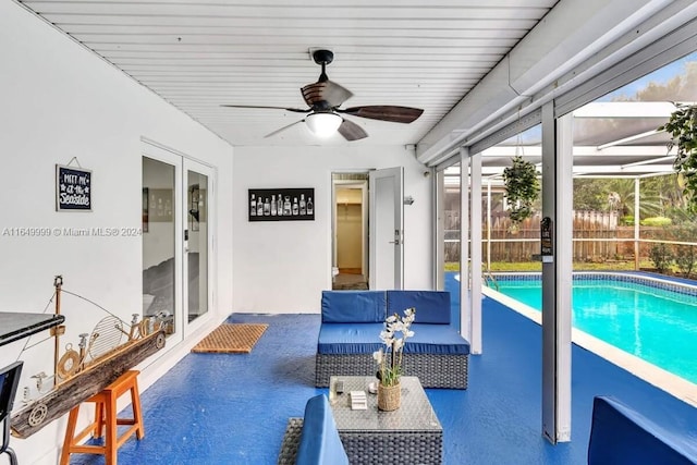 view of swimming pool featuring ceiling fan, a patio area, and glass enclosure