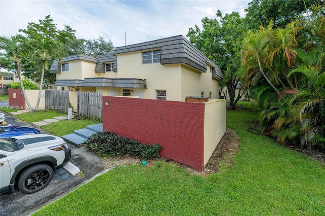 view of side of home with a lawn