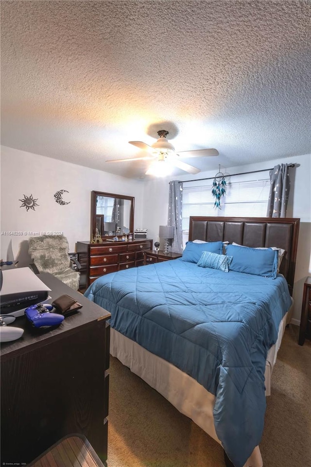 bedroom featuring a textured ceiling, carpet flooring, and ceiling fan