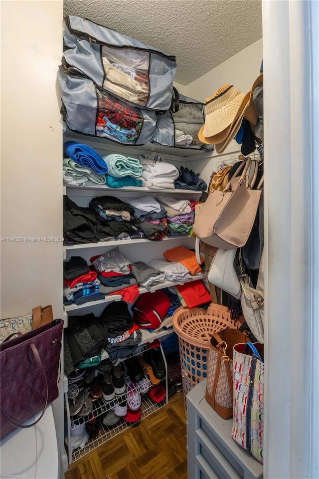 walk in closet featuring dark parquet floors