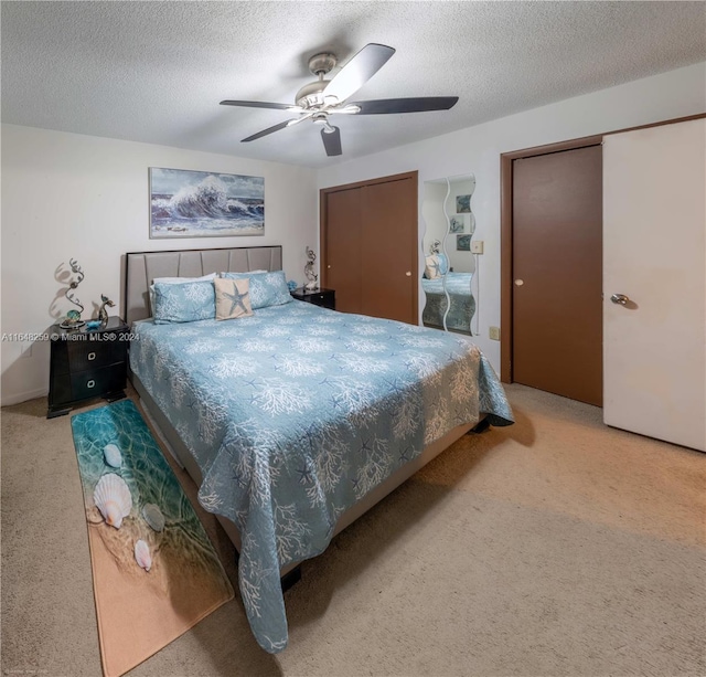 bedroom with a textured ceiling, carpet, a closet, and ceiling fan